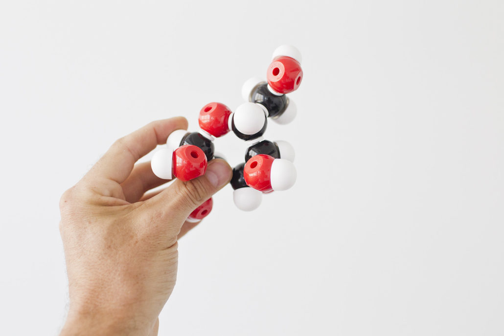 Hand holding a molecular model.