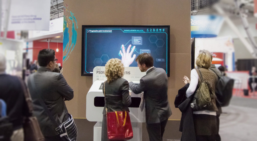 Psoriatic Arthritis Simulator interactive at ACR 2014, Boston. Crowd of conference attendees participating in interactive experience.
