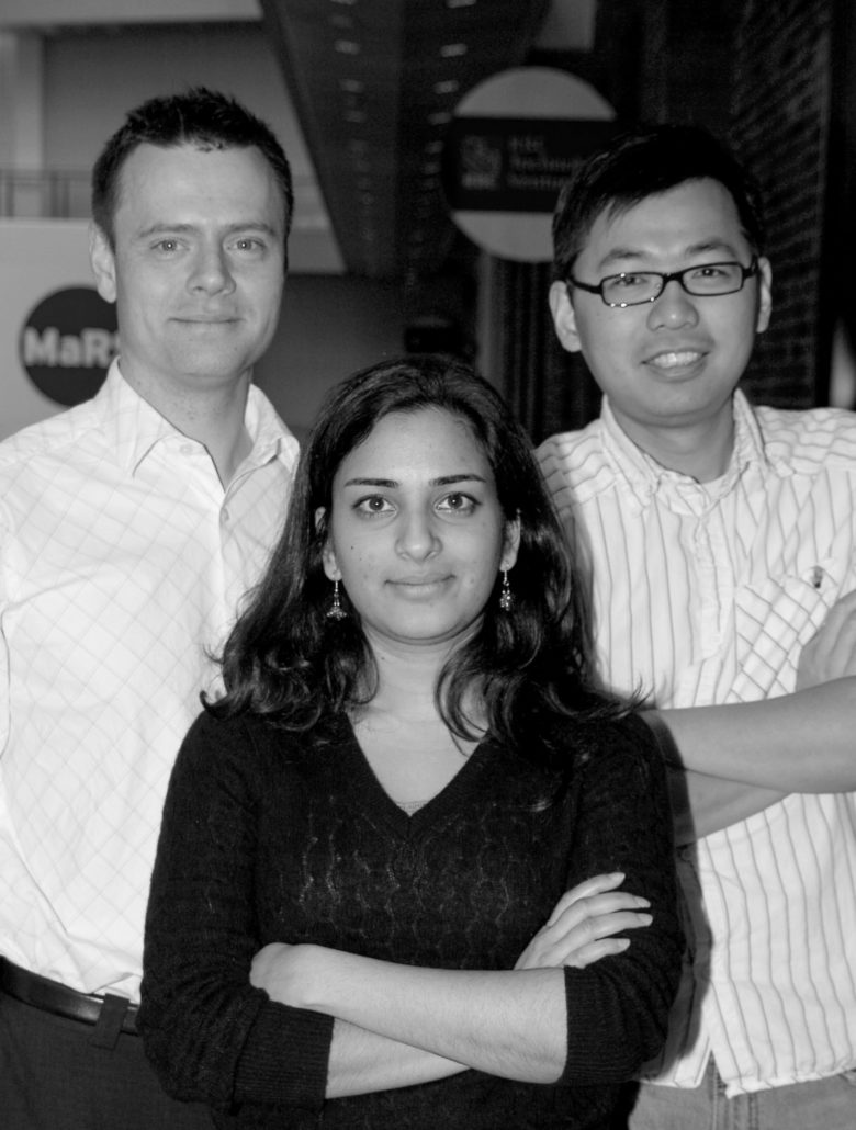 AXS Studio founders Sonya Amin (front), Eddy Xuan (right) and Jason Sharpe (left) in the MaRS buidling on College Street in Toronto. They are smiling and looking into the camera.